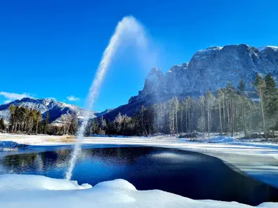 a fountain in the middle of a lake in the snow at Salmsein Biohof in Fiè