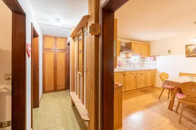 a kitchen with wooden cabinets and a table and a dining room at Salmsein Biohof in Fiè