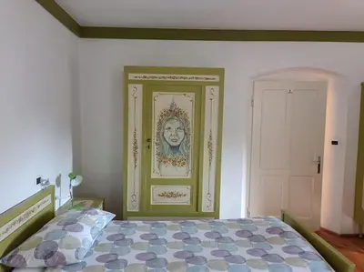 a bedroom with a bed with a painting on the wall at Dolomia in Villagrande