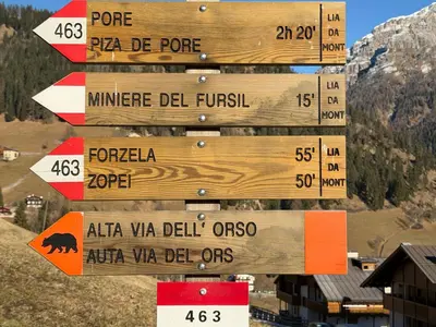 a wooden sign with arrows pointing in different directions at Dolomia in Villagrande