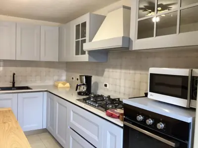 a kitchen with white cabinets and a black stove top oven at Dolomia in Villagrande