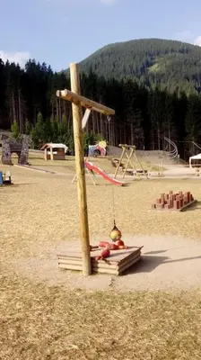 a playground with a wooden pole in the sand at Baita Giggia sulle piste - Cavalese in Trentino Alto Adige cottage chalet in Cavalese