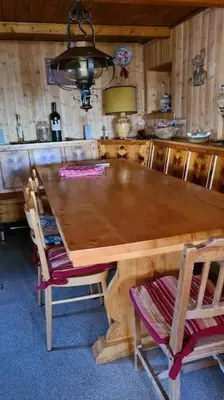 a wooden table and chairs in a room at Baita Giggia sulle piste - Cavalese in Trentino Alto Adige cottage chalet in Cavalese