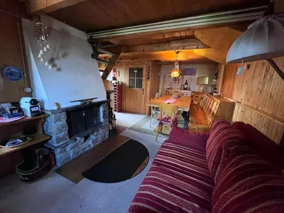 a living room with a couch and a fireplace at Baita Giggia sulle piste - Cavalese in Trentino Alto Adige cottage chalet in Cavalese