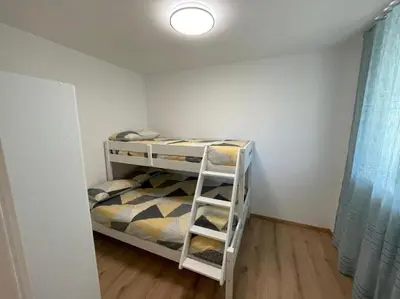 a small bedroom with a bunk bed with a ladder at Apartment LUNA in Tesero