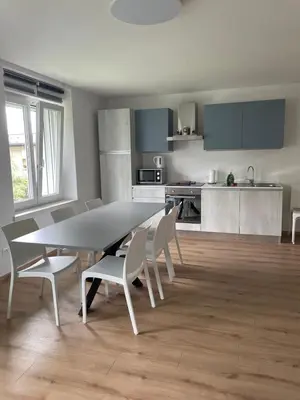 a dining room and kitchen with a table and chairs at Apartment LUNA in Tesero