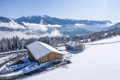 a couple of buildings in a snow covered field at Hoferhof in Maranza