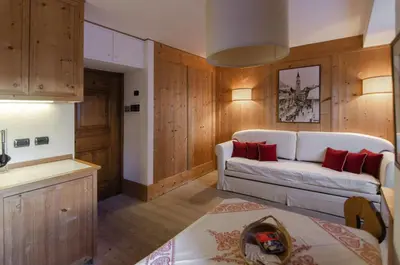 a living room with a white couch and red pillows at Sweet Cristallo in Cortina dʼAmpezzo