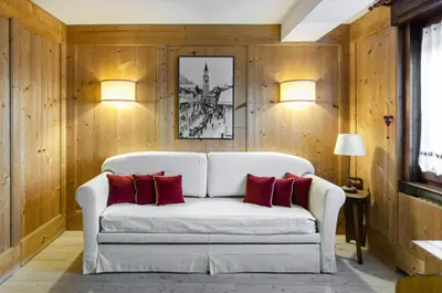 a living room with a white couch with red pillows at Sweet Cristallo in Cortina dʼAmpezzo