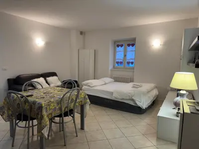 a bedroom with a bed and a table and chairs at Val di Non Apartment in Cles
