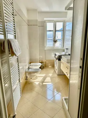 a white bathroom with a toilet and a sink at Val di Non Apartment in Cles
