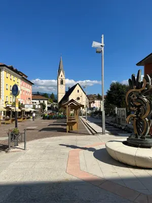 a town square with a clock tower and a statue at Val di Non Apartment in Cles