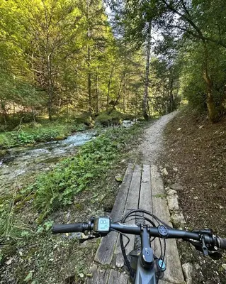 a bike on a wooden bridge over a river at Val di Non Apartment in Cles