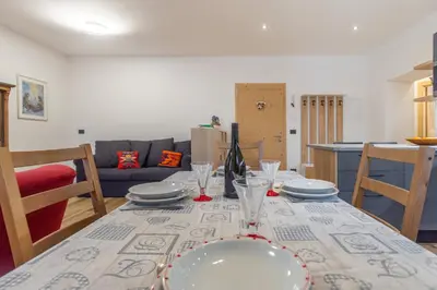 a dining room table with plates and glasses on it at DolomiApartments - Appartamenti Campanil 1 e Campanil 2 in Predazzo