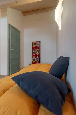 a bedroom with a large bed with blue pillows at DolomiApartments - Appartamento Orso Bruno in Predazzo