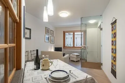 a living room with a table and a dining room at DolomiApartments - Appartamento Orso Bruno in Predazzo