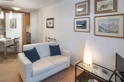 a living room with a white couch and a table at DolomiApartments - Appartamento Orso Bruno in Predazzo
