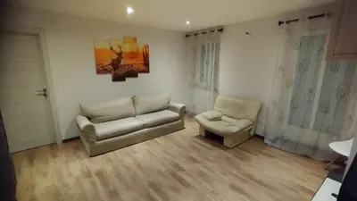 a living room with a couch and a chair at In centro col giardino in Predazzo