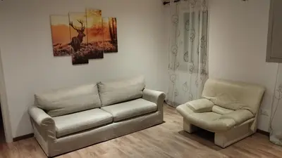 a living room with a couch and a chair at In centro col giardino in Predazzo