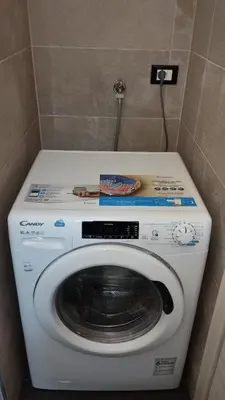 a washing machine in a corner of a bathroom at In centro col giardino in Predazzo