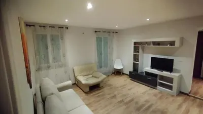 a living room with a couch and a television at In centro col giardino in Predazzo