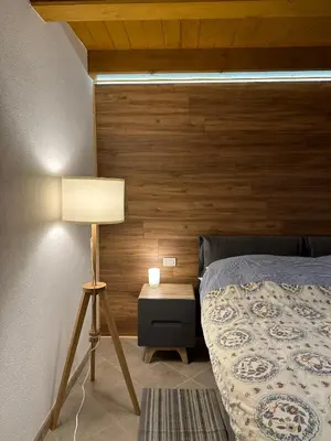 a bedroom with a bed with a wooden wall at Tabia Suite Pelmo in Villagrande