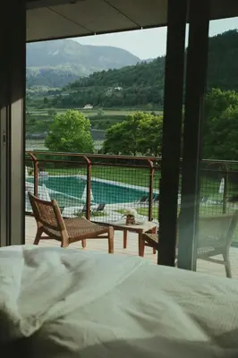 a bedroom with a bed and two chairs and a table at Solterra Poolhouse 1 in Tesimo