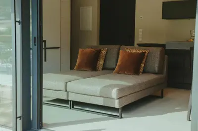 a couch with two pillows on it in a room at Solterra Poolhouse 1 in Tesimo