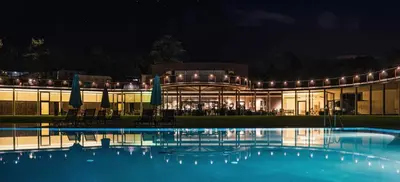 a building with a swimming pool at night at Solterra Poolhouse 1 in Tesimo