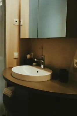 a bathroom with a white sink and a mirror at Solterra Poolhouse 1 in Tesimo