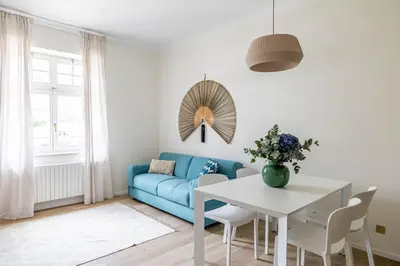 a living room with a blue couch and a table at Italyescapes Emma 22 in Merano