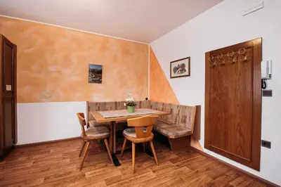 a dining room with a wooden table and chairs at Gästehaus Marianne Terenten in Terento