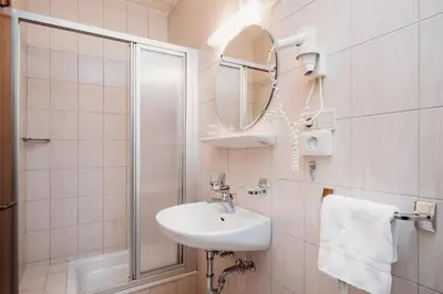 a bathroom with a sink and a shower and a mirror at Gästehaus Marianne Terenten in Terento