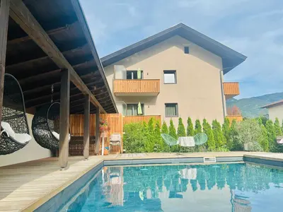 a house with a swimming pool in front of a house at Rosalie Apartments in Lana
