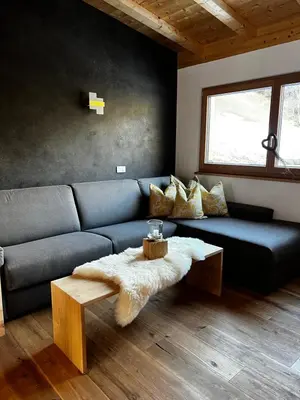 a living room with a blue couch and a table at Lüch dl Finatzer in San Martino in Badia