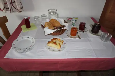 a table with plates of bread and drinks on it at Neuhäusl-Hof in San Genesio Atesino