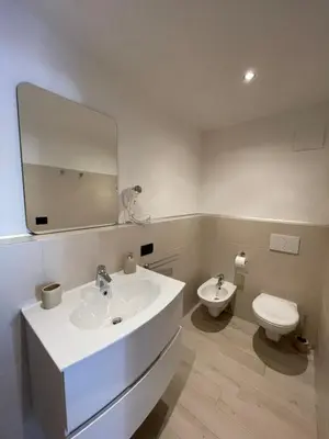 a bathroom with a sink and a toilet and a mirror at Neuhäusl-Hof in San Genesio Atesino