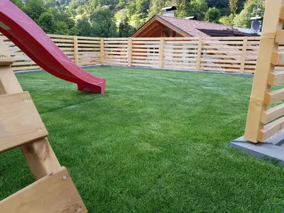a playground with a slide and a wooden fence at Neuhäusl-Hof in San Genesio Atesino