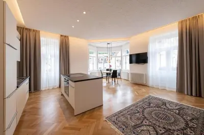 a large living room with a kitchen and a dining room at Meranosuites in Merano