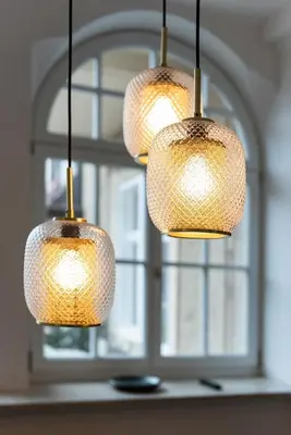 a group of three lights hanging in front of a window at Meranosuites in Merano