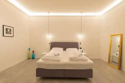 a bedroom with a bed and a mirror at Meranosuites in Merano