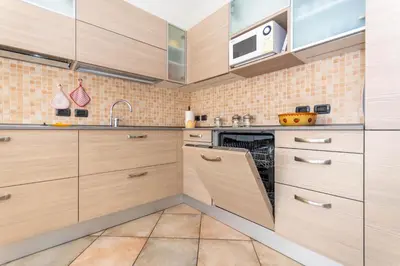 a kitchen with wooden cabinets and a microwave at Casa Freina in Vigo di Fassa