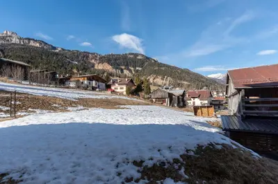 a village in the mountains with snow on the ground at Casa Freina in Vigo di Fassa