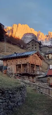a wooden building with a mountain in the background at Chalet-Tabià al Sol montagna Dolomiti Pecol in San Tomaso