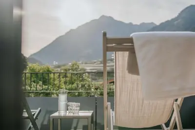 a balcony with a chair and a table with a view at chez mone&harry in Lagundo