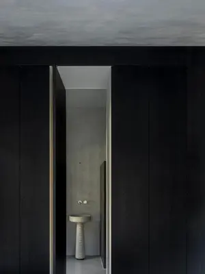 a hallway with black walls and a white stool in a room at chez mone&harry in Lagundo