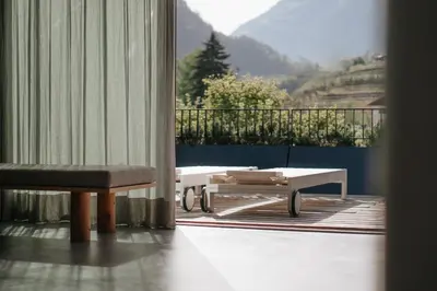 a room with a bench and a table and a balcony at chez mone&harry in Lagundo