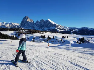 a young child is skiing down a snow covered mountain at Apartment Cesa Collina Superior in Ortisei