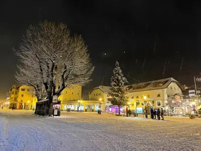 a snow covered town with a christmas tree and buildings at Apartment Cesa Collina Superior in Ortisei