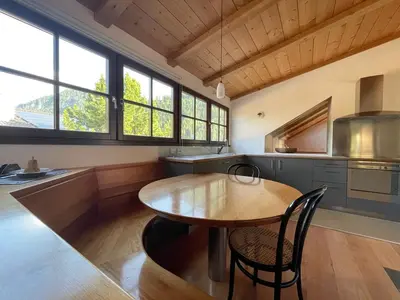a kitchen with a wooden table and some windows at Apartment Cesa Collina Superior in Ortisei